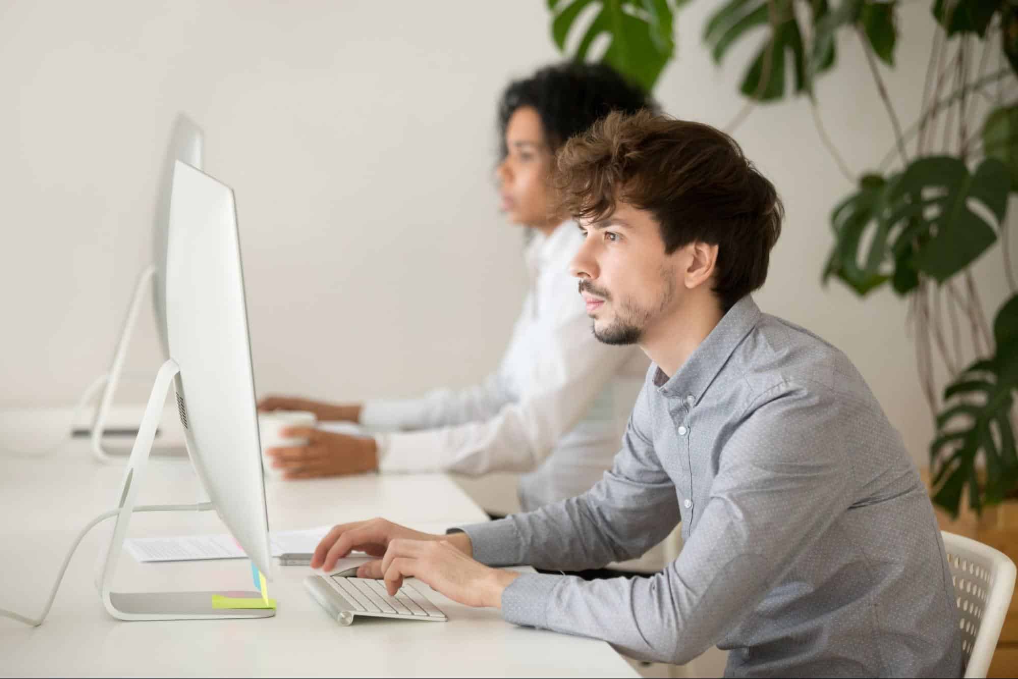 Employee managing social media content and digital marketing tasks on a desktop computer in a modern office.